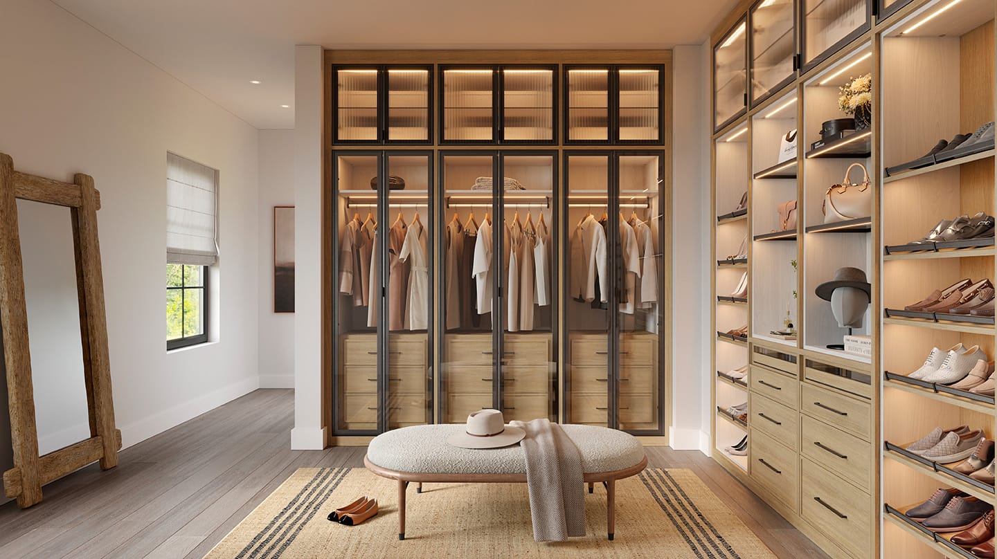 A walk in closet design with custom shoe racks, shelving, drawers and LED lighting envisioned by California Closets